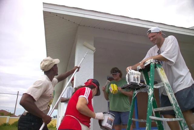 Participants painting a home together in the FNPH self-help housing archive.